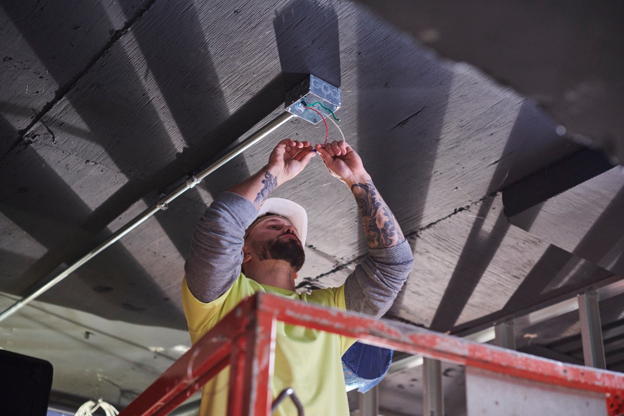 White electrician working on receptacle box